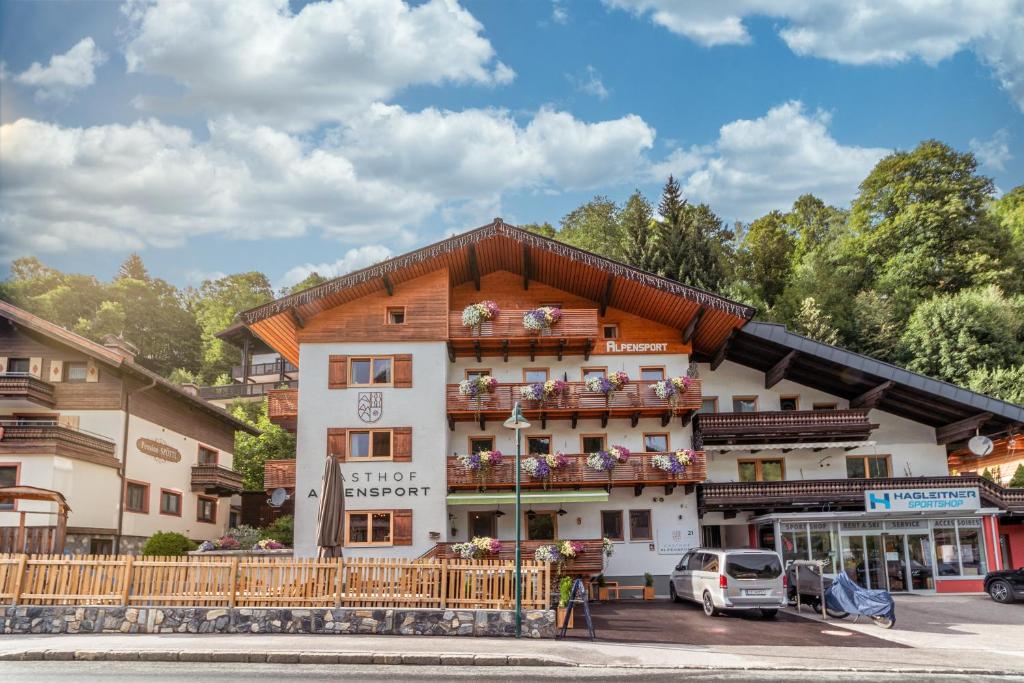 a building in a town with cars parked in front at Gasthof Alpensport - inklusive Joker Card in Saalbach-Hinterglemm