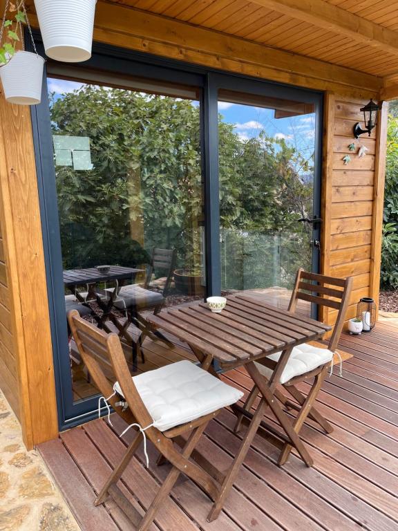 a wooden deck with a picnic table and chairs at Lagoon Tiny House in Arcos de Valdevez