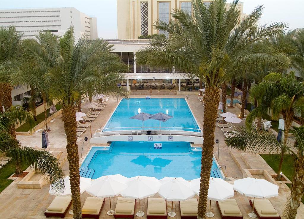 vista sul tetto di una piscina con palme di Leonardo Royal Resort Eilat a Eilat