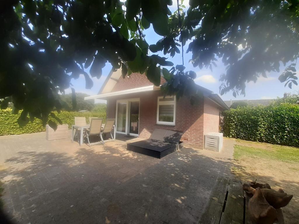 una casa con patio arredato con sedie e tavolo di De Steegberg Holiday Home a Sevenum