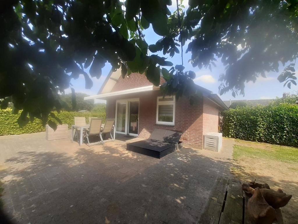 een huis met een patio met stoelen en een tafel bij De Steegberg Holiday Home in Sevenum