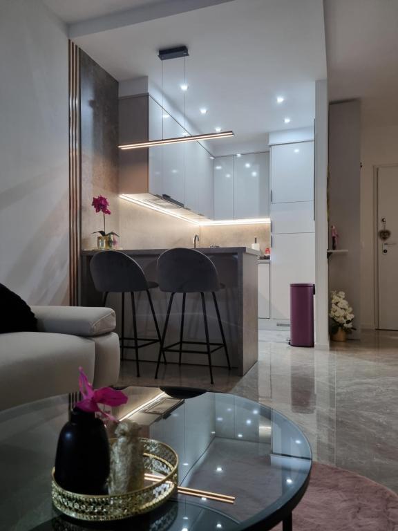 uma sala de estar com um sofá e uma mesa de vidro em Apartment "50 Shades" with balcony and free parking in the garage em Zadar