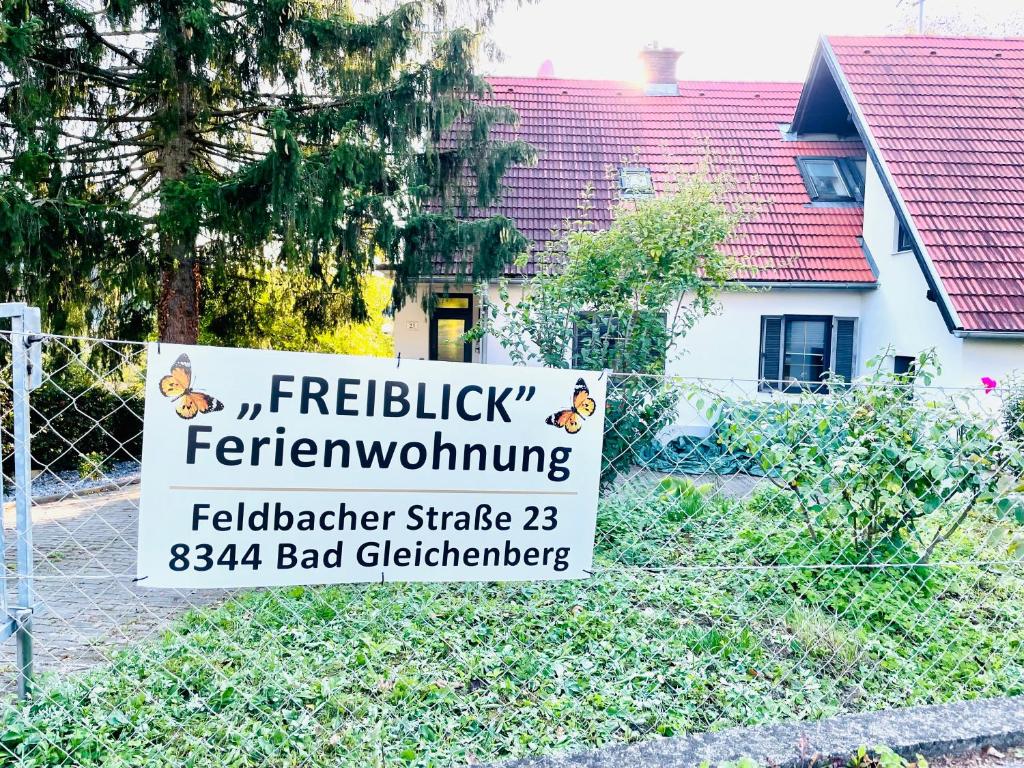 un cartello su una recinzione di fronte a una casa di Freiblick 1 Bad Glbg mit Garten Top1 a Bad Gleichenberg