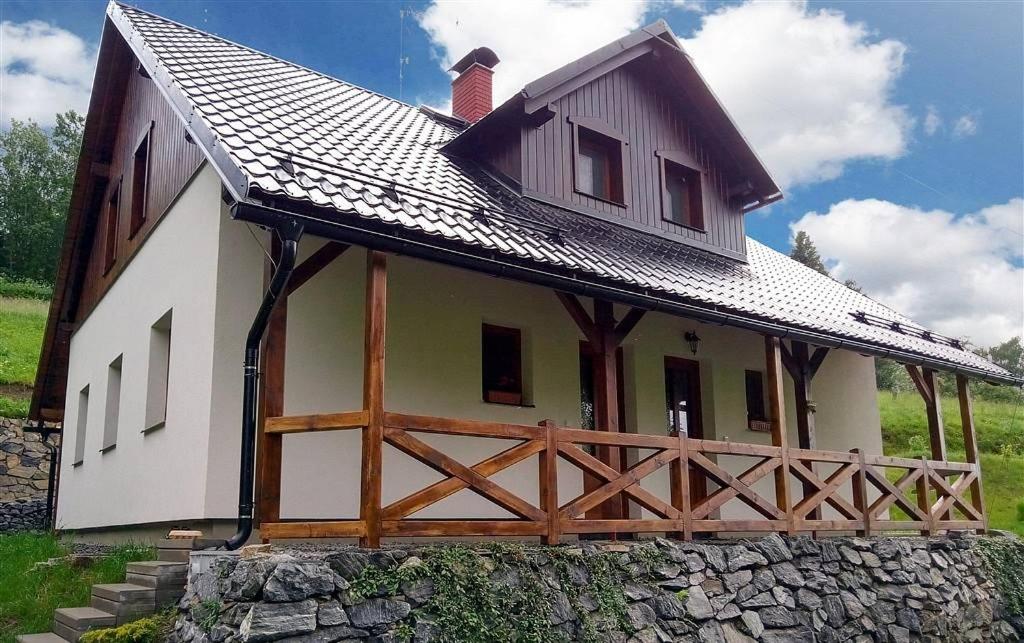 a large white house with a wooden roof at Chalupa Maršíkov 120 in Velké Losiny