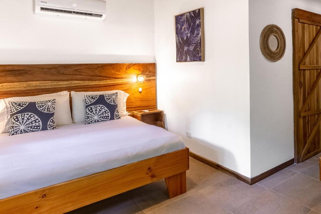 een slaapkamer met een bed in een kamer bij Makanas Beach Bungalows in Santa Teresa Beach
