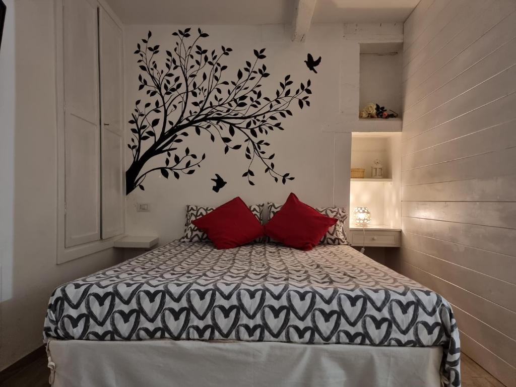 una camera da letto con un letto con cuscini rossi e un albero di Dimora San Francesco a Bevagna