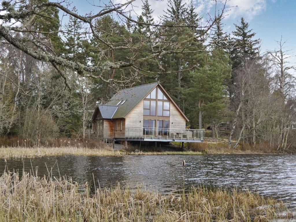 a house sitting on the side of a lake at Golf View in Aboyne