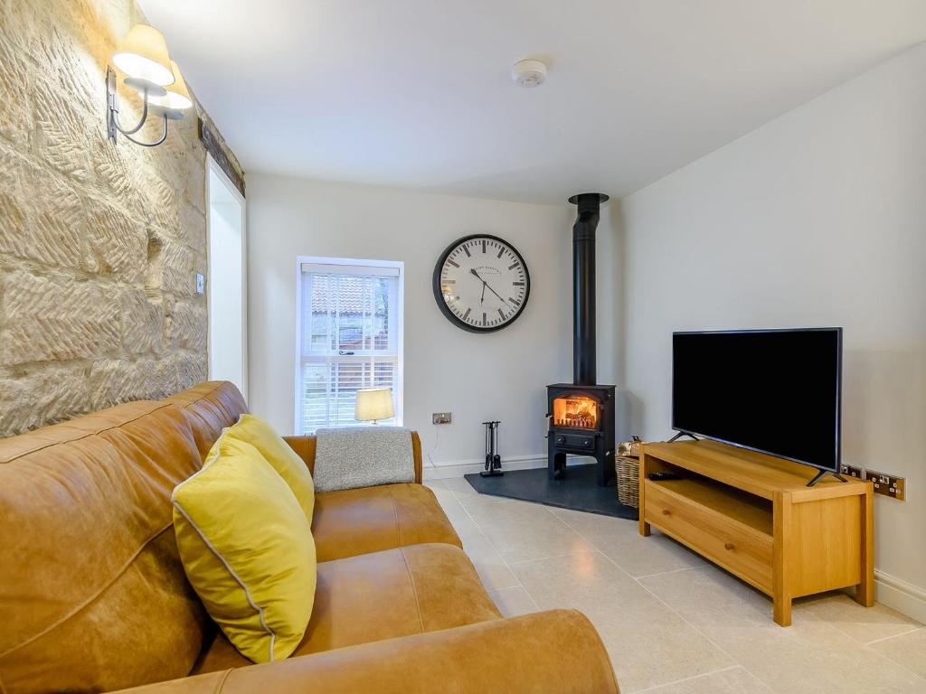 a living room with a couch and a tv and a fireplace at The Nook - Uk36720 in Glaisdale