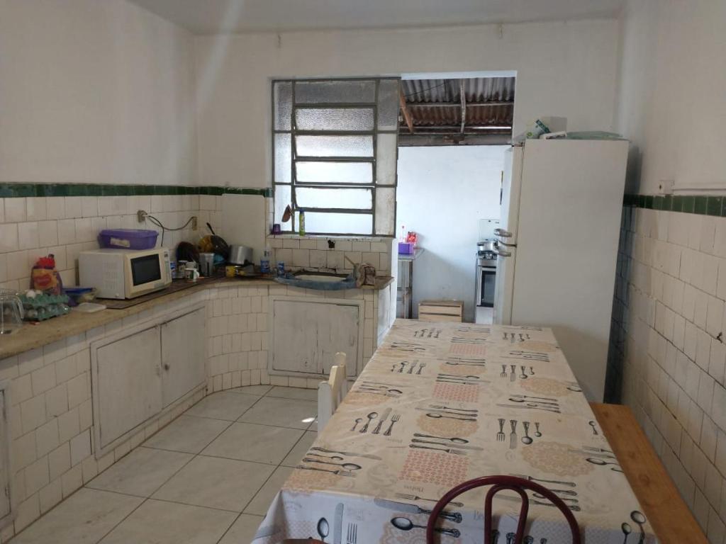 a kitchen with a table and a refrigerator at Hostel Cachoeira in Porto Alegre