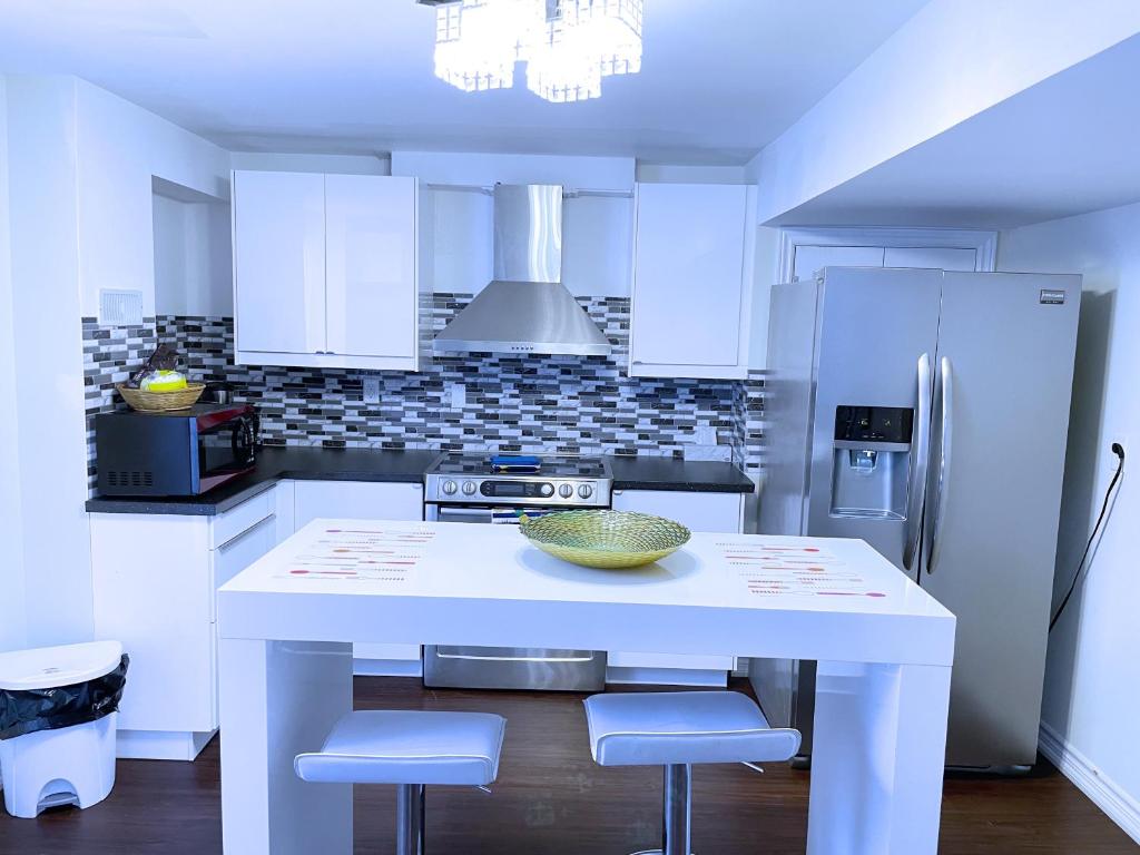 a kitchen with a white island with stools in it at WELCOME TO PREMIUM LIVING PLACE / 2 BEDROOMS SUITE in Innisfil