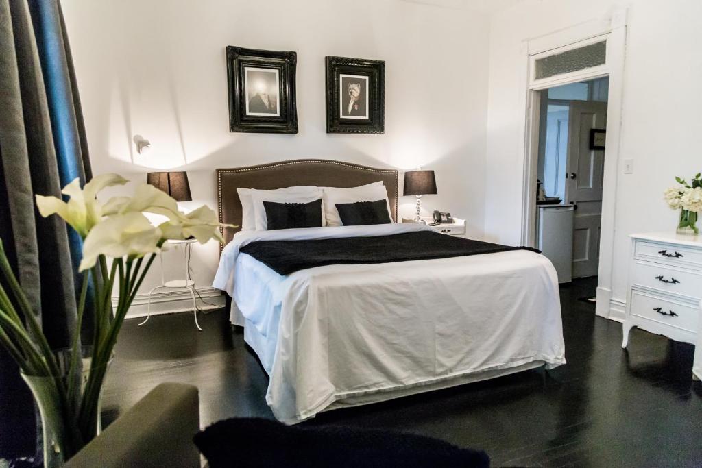 ein Schlafzimmer mit einem Bett mit einer schwarzen Decke in der Unterkunft Manoir Becancourt Hotel in Bécancour