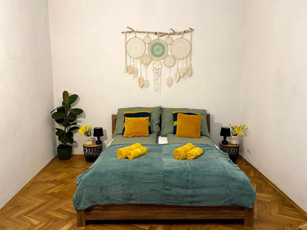 a bedroom with a bed with two yellow pillows at Green House apartments in Krakow