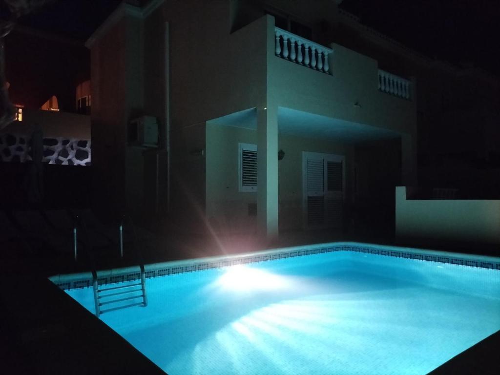 una piscina por la noche con un edificio en el fondo en Casa Mariben, Vacation Rental home Vv 3 Bedrooms private pool with sea views, en Callao Salvaje