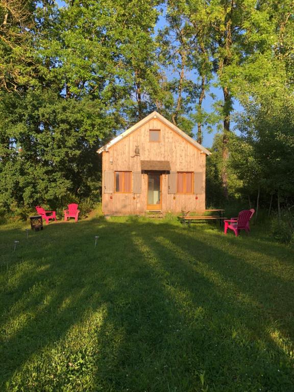 a barn with a picnic table and chairs in a yard at Tiny-House sous les arbres et les oiseaux 