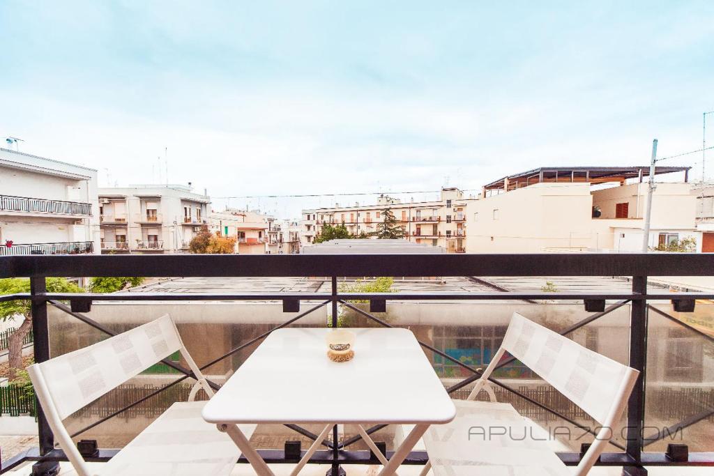 a white table and chairs on a balcony with a view at Apulia 70 Holidays in Polignano a Mare