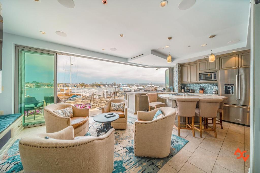 a kitchen and living room with a view of the ocean at Beach House Steps from Balboa Ferry in Newport Beach