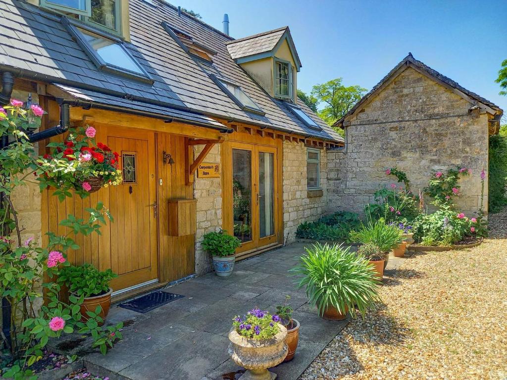 a house with a courtyard with potted plants at Carpenters Barn in Combrook