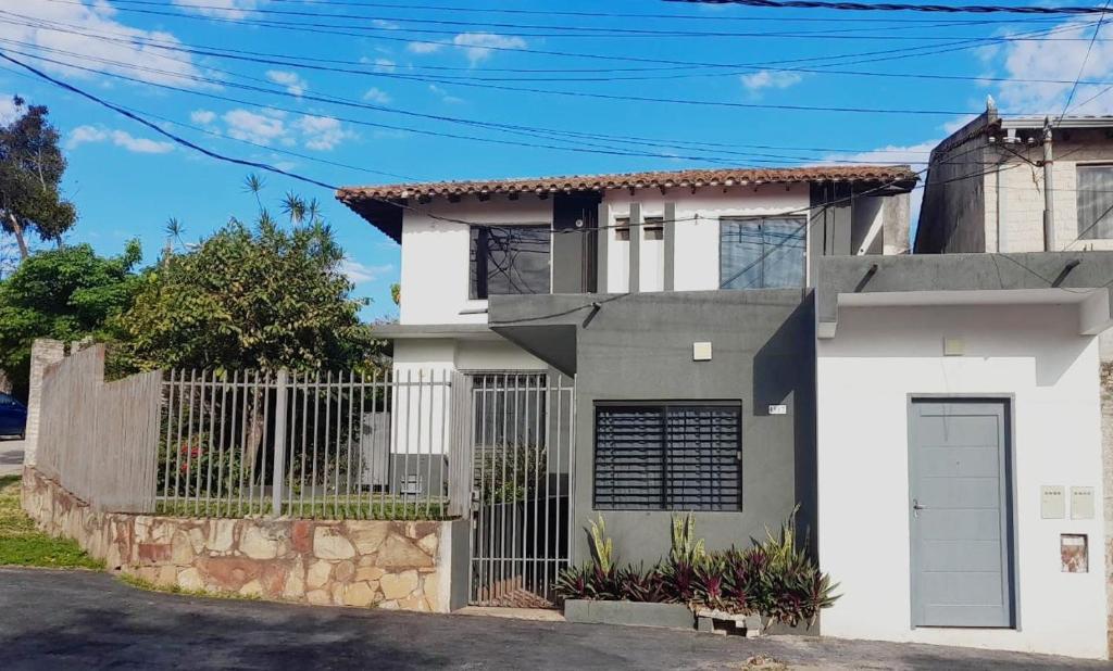una casa blanca con una puerta y una valla en Apartamentos Victoria en Asunción