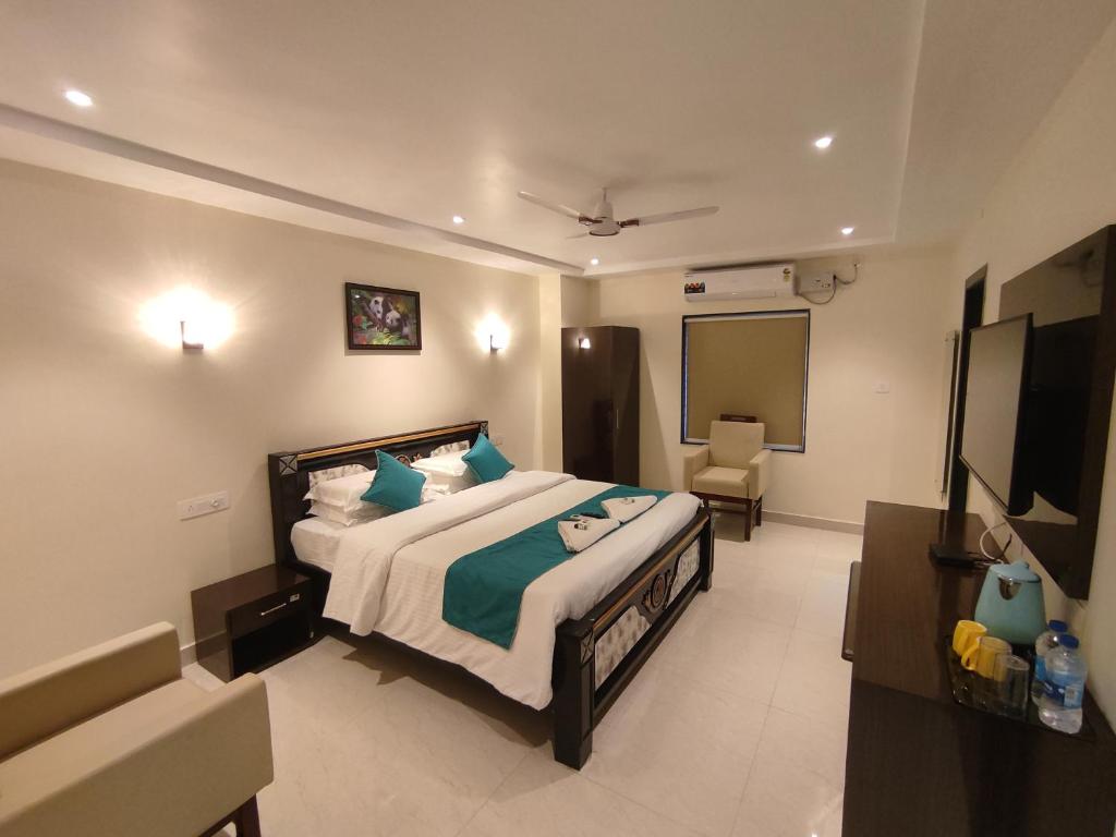 um quarto de hotel com uma cama e uma televisão em Jazzy Beach Guest House em Visakhapatnam