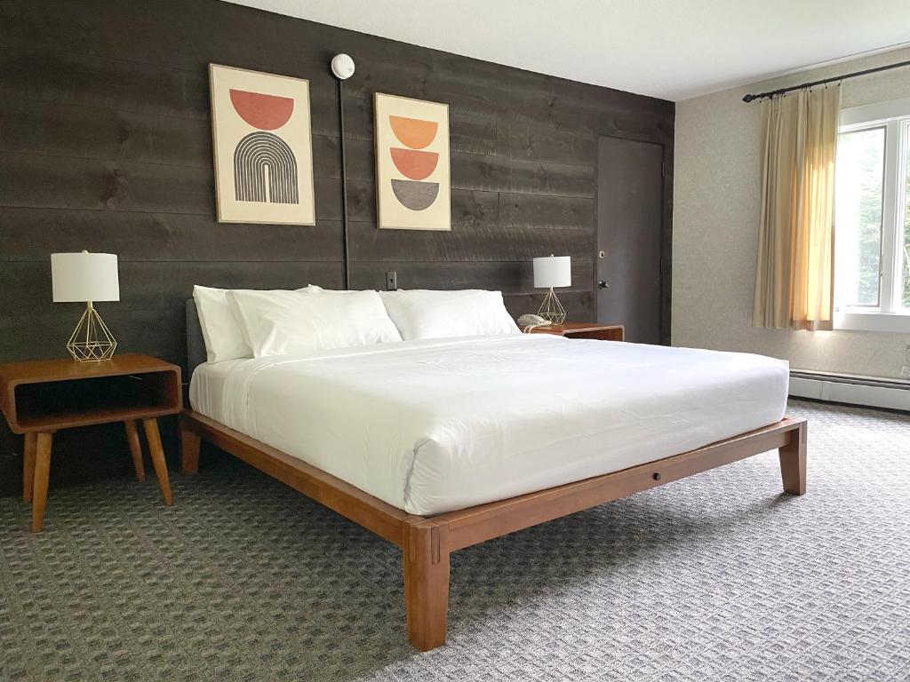 a bedroom with a large white bed with a wooden headboard at Toll Road Inn in Manchester