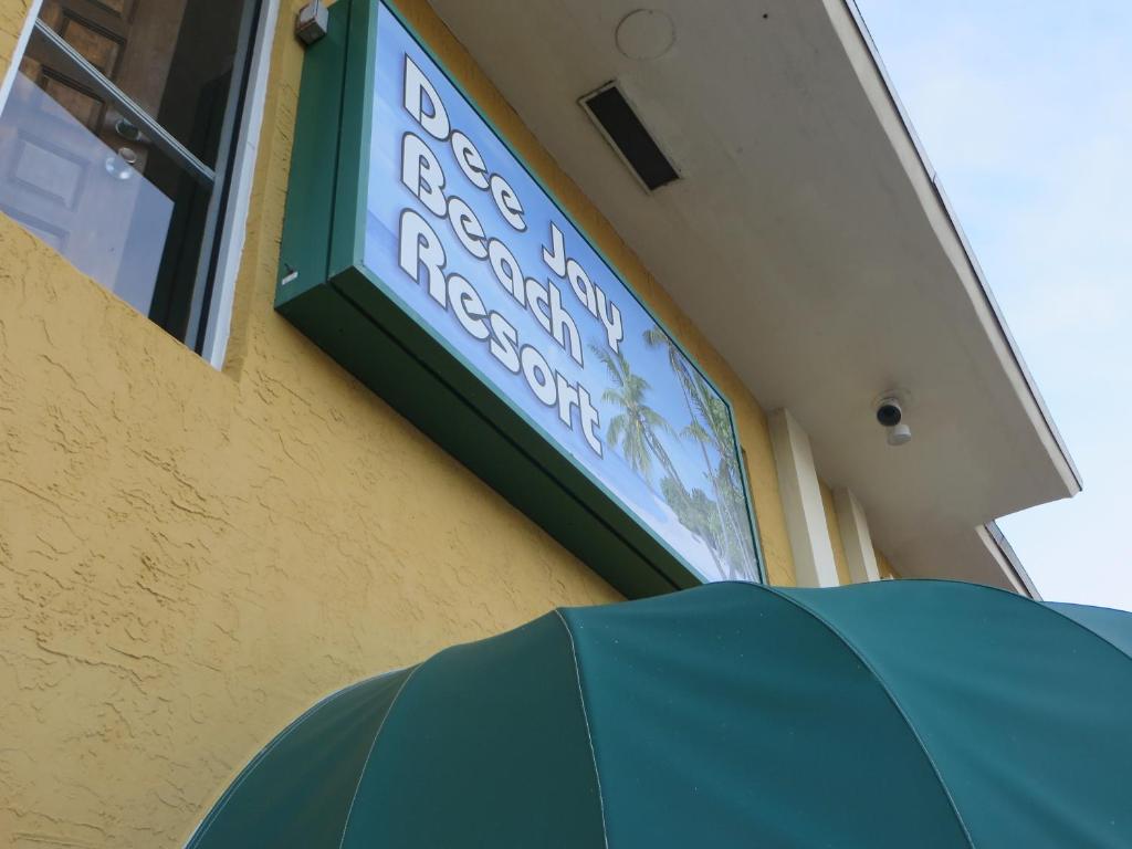 a sign on the side of a restaurant with an umbrella at Dee Jay Beach Resort in Fort Lauderdale