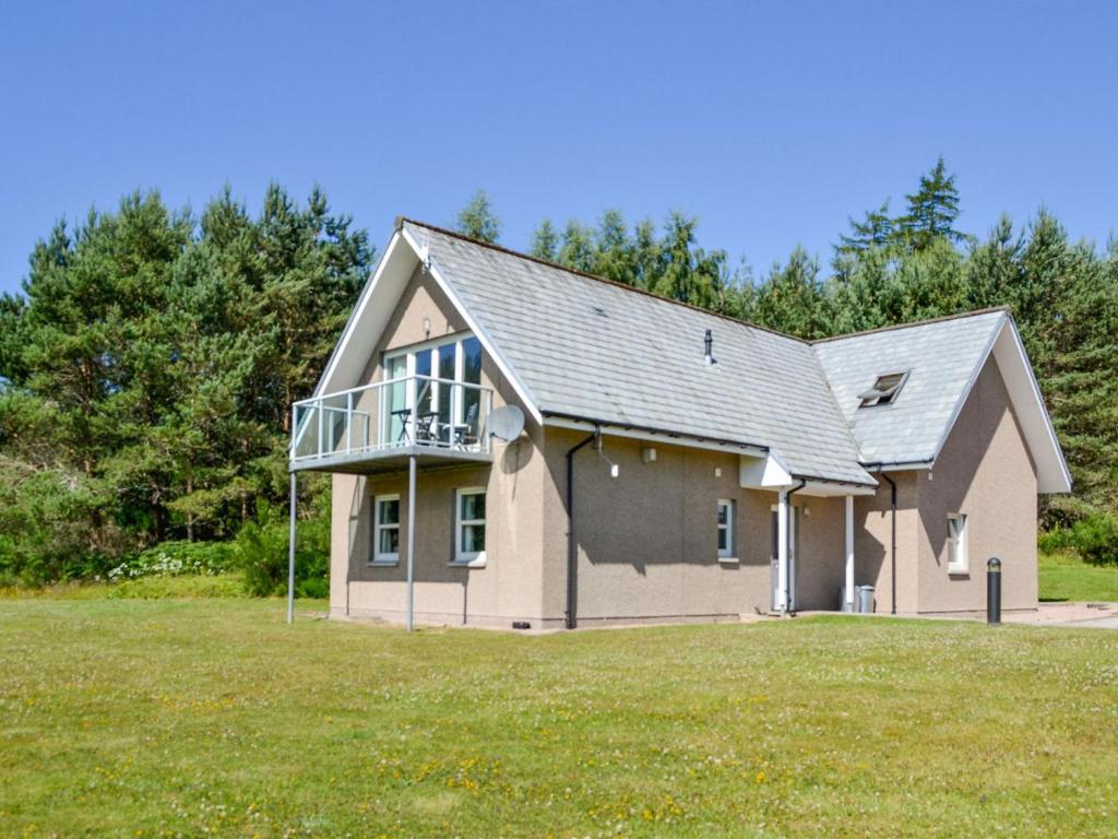 a large house with a balcony on top of it at Queens View Lodge in Inchmarlo