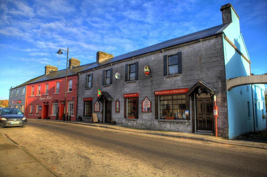 a building on a street with a car parked in front at Ryan's Hotel in Cong