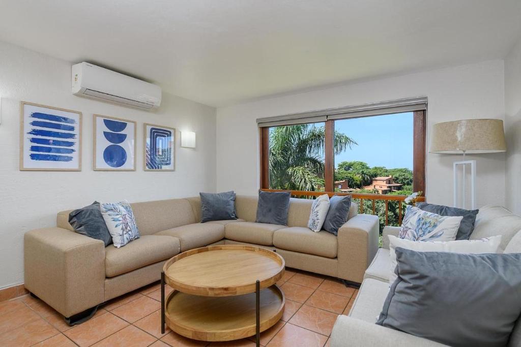 a living room with a couch and a table at San Lameer Style by Top Destinations Rentals in Southbroom