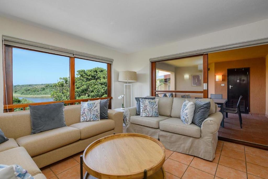 ein Wohnzimmer mit Sofa und Tisch in der Unterkunft San Lameer Style by Top Destinations Rentals in Southbroom