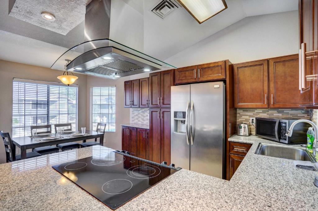 a kitchen with a stainless steel refrigerator and a table at Pet-Friendly Condo with Pool about 7 Mi to Dtwn Chandler in Chandler