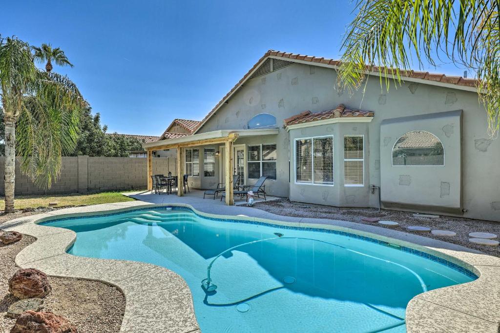 a house with a swimming pool in front of it at Chic Phoenix Home with Yard and Private Heated Pool! in Phoenix