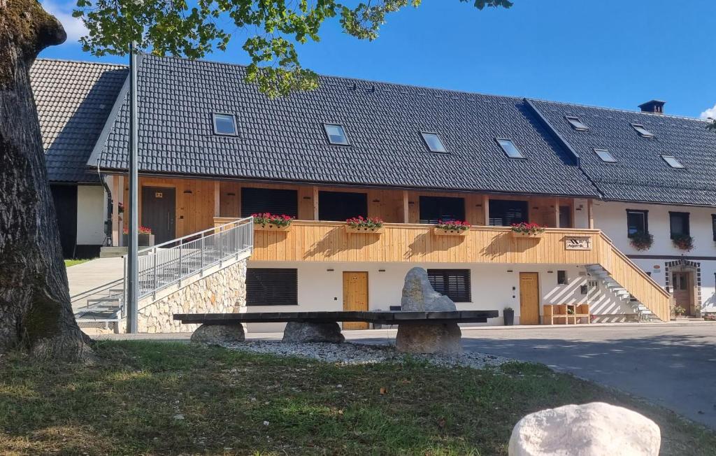 a bench in front of a building with a roof at Pr `Agotnik Apartments & Rooms Bohinj in Bohinj