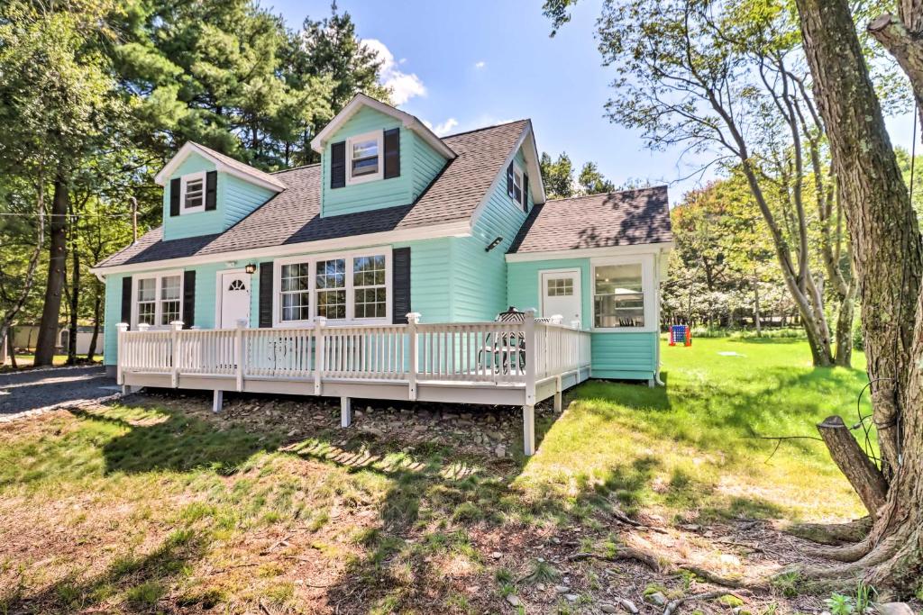 una casa azul con porche y patio en Game Room, Community Beach Pocono Home!, en Albrightsville