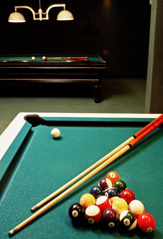 two pictures of a pool table with balls and cues at Best Western Plus Hostellerie Du Vallon in Trouville-sur-Mer