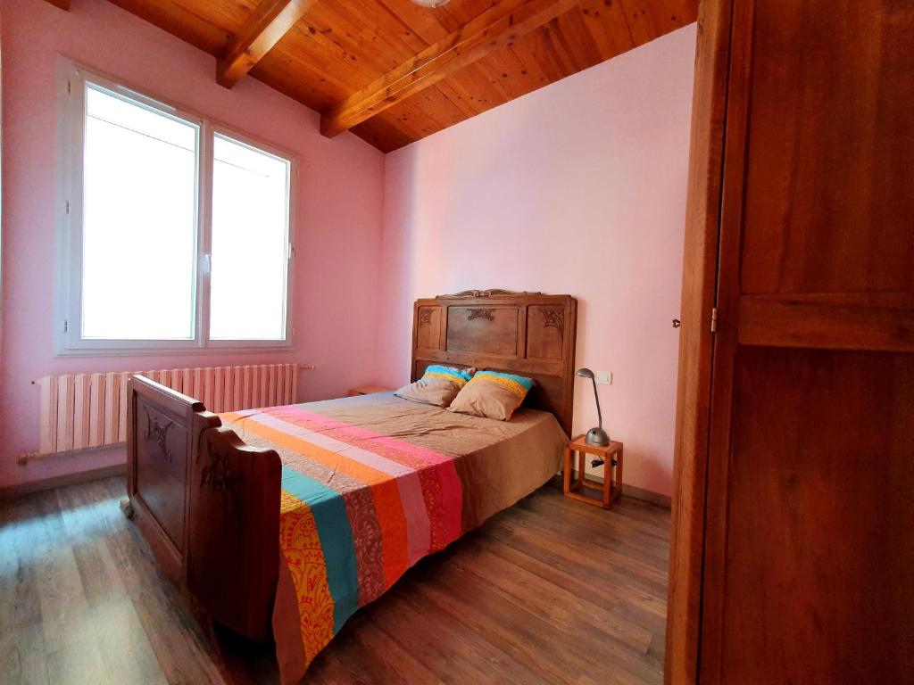 1 dormitorio con 1 cama con una manta colorida en Appartement au calme au cœur du village, en Saint-Beauzély