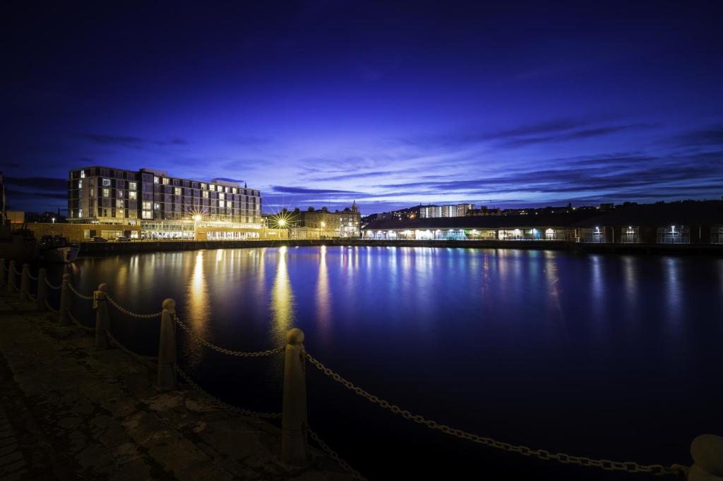 a large body of water at night with buildings at Apex City Quay Hotel & Spa in Dundee