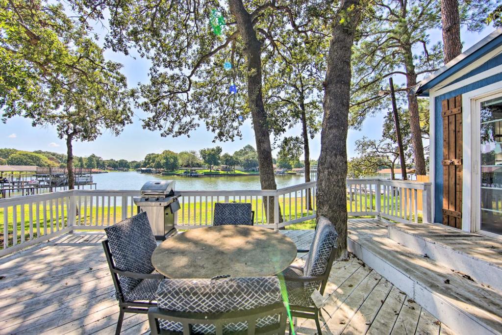 a table and chairs on a deck with a view of the water at Gun Barrel City Lake House with Boat Launch and Grill! in Gun Barrel City