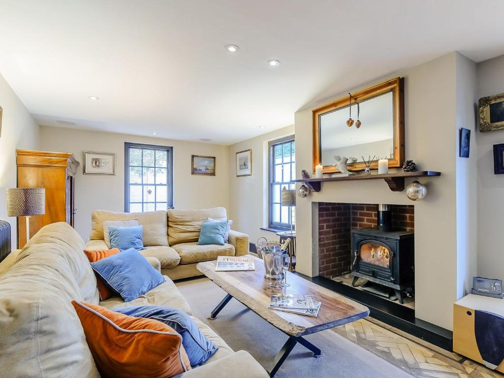 sala de estar con sofá y chimenea en Anchor Light Cottage en Faversham