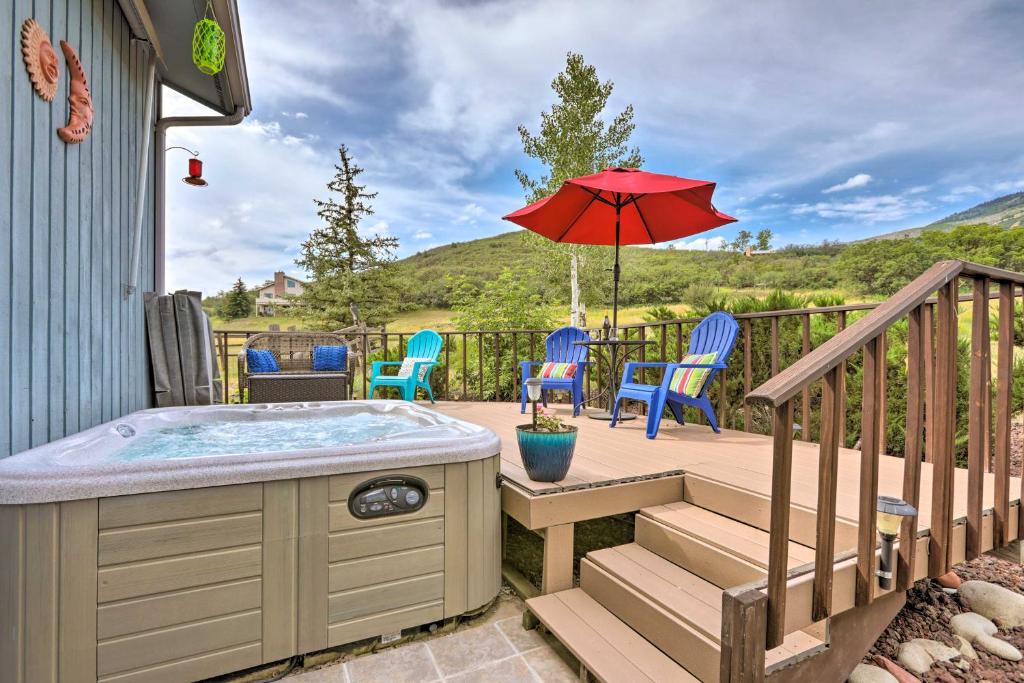 - un bain à remous sur une terrasse avec des chaises et un parasol dans l'établissement Sunlight Mountain Home with Hot Tub and View!, à Carbondale