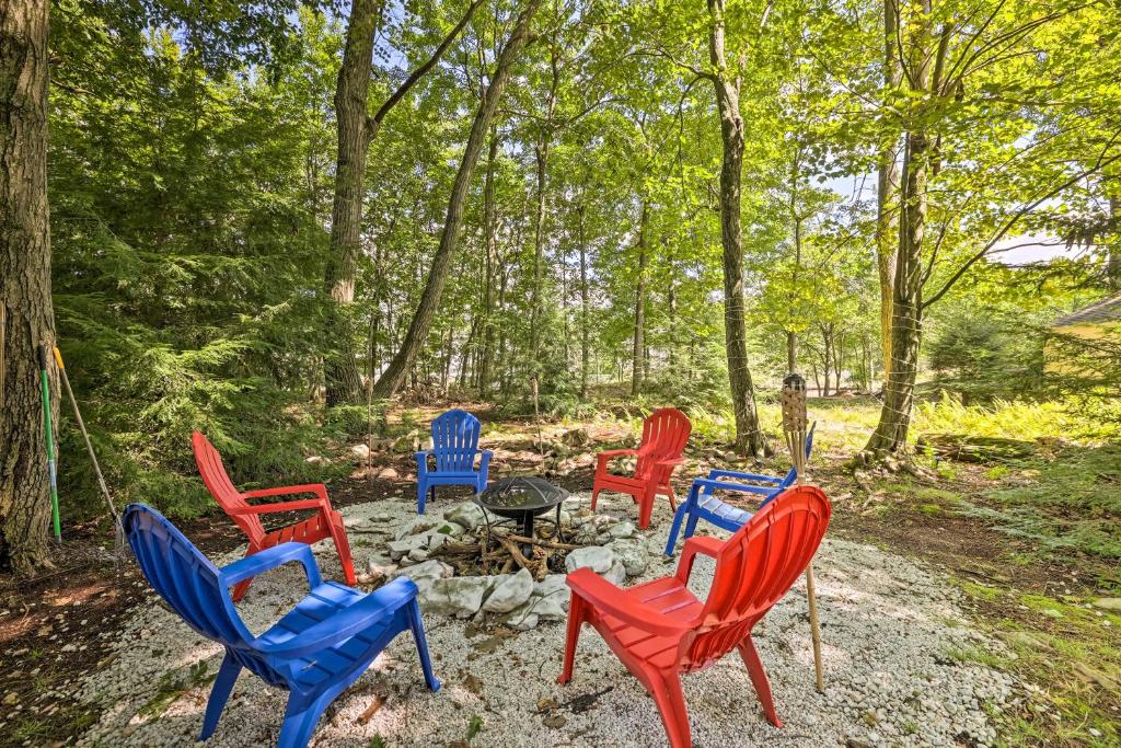a group of colorful chairs sitting around a fire pit at Walk to Lake Game Room Getaway in Pocono Summit! in Pocono Summit