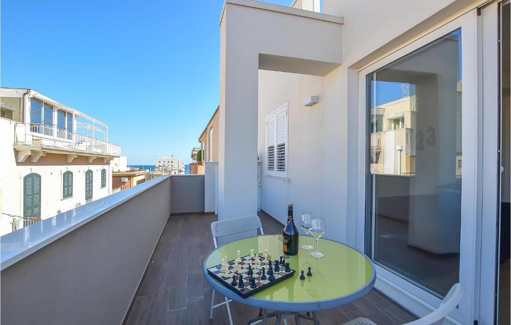 een kamer met een tafel en een schaakbord op een balkon bij Beautiful Apartment In Pozzallo With Kitchen in Pozzallo