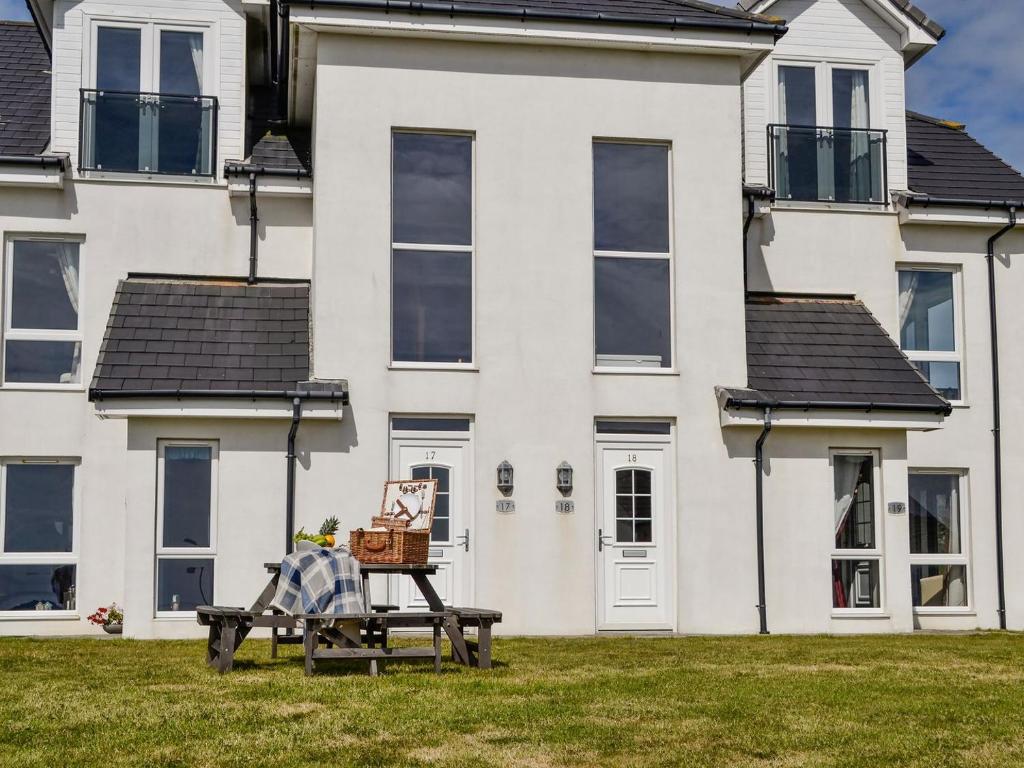 uma casa com uma mesa de piquenique em frente em Seaviews And Hot Tub At The Fairways - Uk39821 em Portpatrick