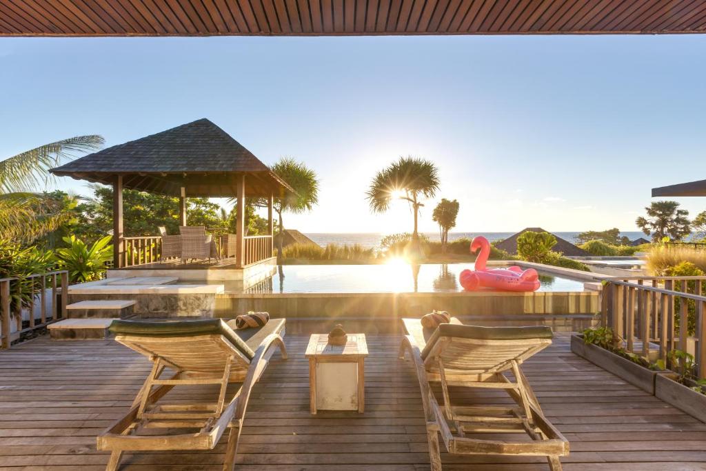 a deck with chairs and a gazebo at The Chand's Boutique Villa Batu Belig in Seminyak