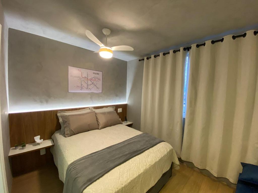 een slaapkamer met een bed en een plafondventilator bij Maravilhoso Apartamento em frente ao Metrô Brás ! in Sao Paulo