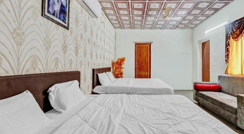 a hotel room with two beds and a couch at Bluerock Resort in Tirupati