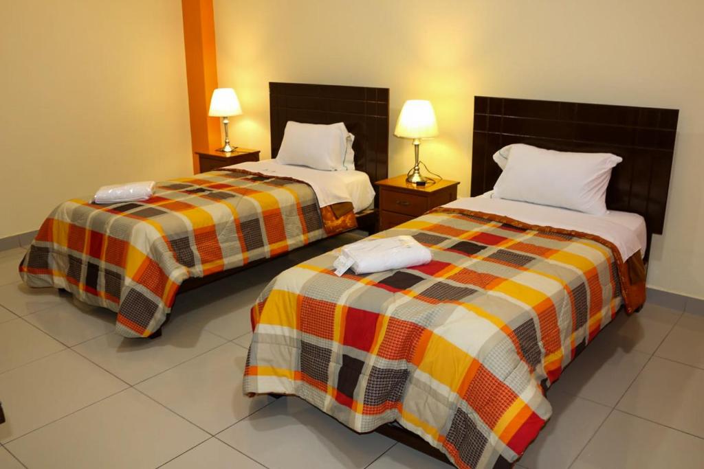 Postel nebo postele na pokoji v ubytování Hotel Las Palmeras