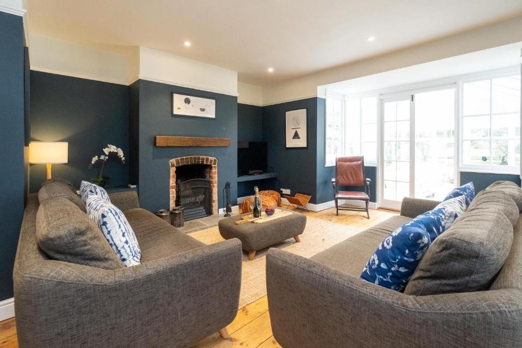 a living room with two couches and a fireplace at Pinewood - Aldeburgh Coastal Cottages in Aldeburgh