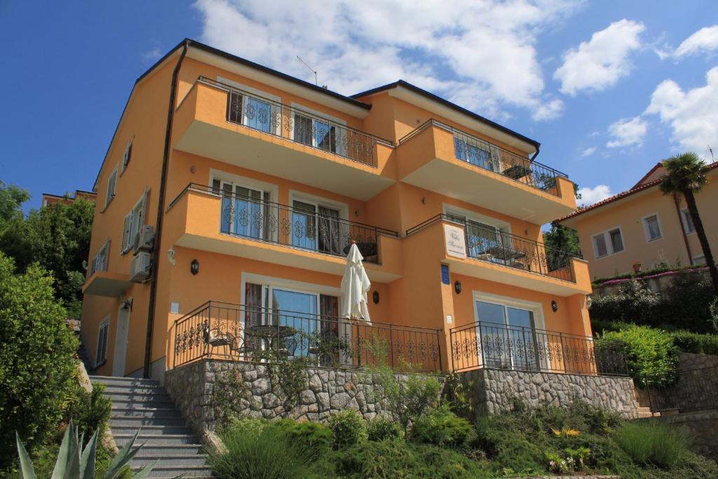 a yellow building with stairs in front of it at Apartments with a parking space Icici, Opatija - 7785 in Ičići