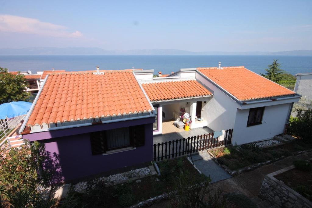 two white houses with orange roofs and the ocean at Apartments with a parking space Ravni, Labin - 7674 in Ravni