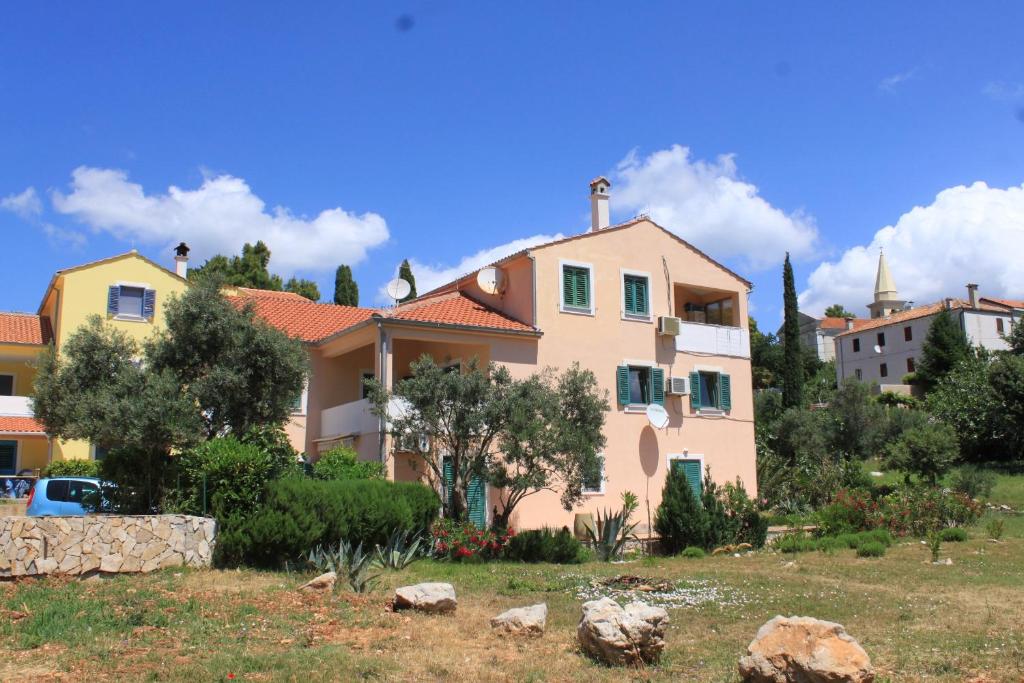 a large house with a yard in front of it at Apartments with a parking space Sveti Jakov, Losinj - 8011 in Nerezine